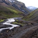 Dalgång i Islands inland med grusväg.