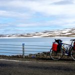 Snö och is vid sjö med långfärdscykel